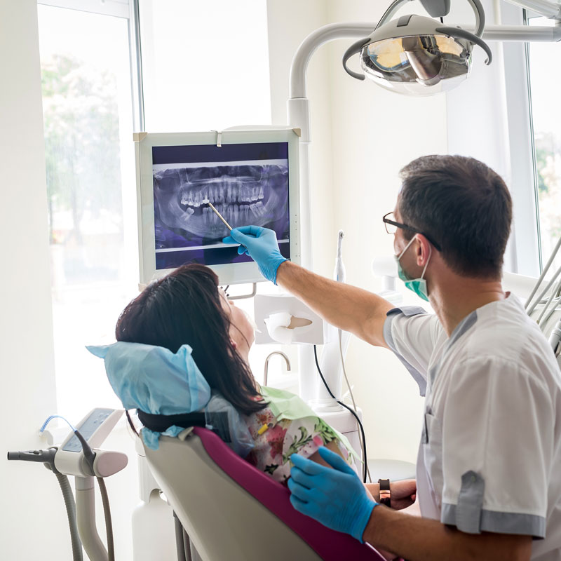 dentist point to tooth on patient's x-ray